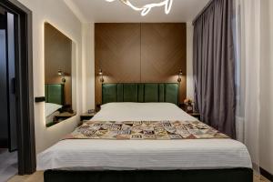 a bedroom with a large bed with a green headboard at EV Hotel Baytik in Verkhnyaya Alaarcha