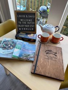 a table with two books and two cups of coffee at The Hutch Devon in Longdown +30 photos