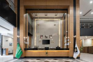 a lobby with a desk with a television and a flag at Elaf Bakkah Hotel in Mecca