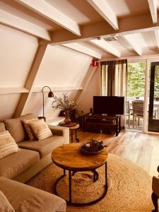 ein Wohnzimmer mit Sofa und Tisch in der Unterkunft Chalet Woods in Durbuy