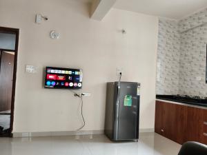 a kitchen with a refrigerator with a tv on the wall at Prolife Tathwade in Méribel Village