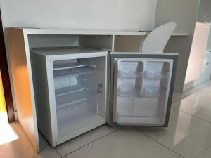 an empty refrigerator with its door open in a kitchen at Goiana Palace Hotel - Perto da JEEP, KLABIN, HEMOBRÁS, VIVIX in Goiana