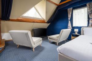 a bedroom with two chairs and a bed and a window at Maison Le Reflet de Marne - Welkeys in Vaires-sur-Marne