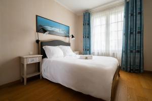 a bedroom with a large white bed and a window at Maison Le Reflet de Marne - Welkeys in Vaires-sur-Marne +22 photos