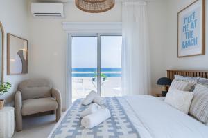 a bedroom with a bed with a chair and a window at Compass 1-BR Apartment by Makenzy Beach in Larnaca