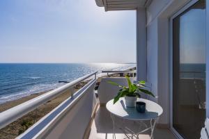 a balcony with a table and a view of the beach at Compass 1-BR Apartment by Makenzy Beach in Larnaca