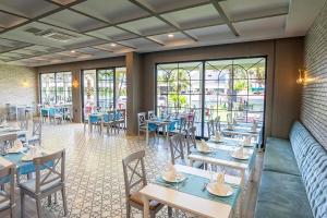 a dining room with tables and chairs and windows at Alder Garden Resort -Ultra All Inclusive in Kemer