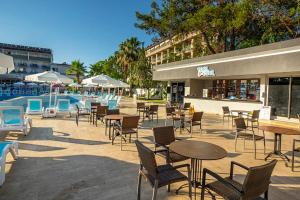a patio with tables and chairs next to a pool at Alder Garden Resort -Ultra All Inclusive in Kemer