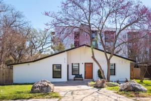 a white house with a tree in a yard at Extended Stay SoCo Oasis Outdoor TV, Heavenly Bed, Long Stay Ready in Austin
