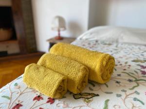 two yellow towels sitting on top of a bed at B&B Luci del porto in Genoa