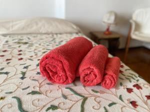 two red towels sitting on top of a bed at B&B Luci del porto in Genoa +12 photos