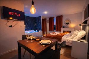 a hotel room with a bed and a table with wine glasses at l'Escale Royale in Rambouillet