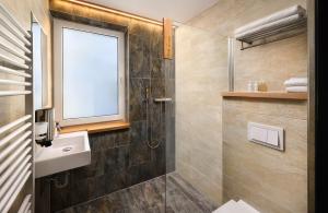 a bathroom with a shower and a sink and a window at Vila Emma in Štrbské Pleso +36 photos