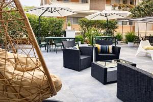 a patio with chairs and tables and umbrellas at Hotiday Firenze Vespucci in Florence