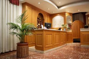 a lobby with a desk with a palm plant in it at Hotiday Firenze Vespucci in Florence