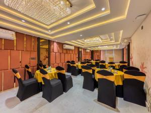 a banquet hall with yellow tables and black chairs at Zip by Spree Hotels R Group Kota - Near Coaching Hub & Oxy Park in Kota