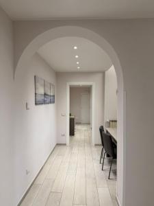 an empty room with a table and chairs and an archway at Rosy Bed&Breakfast in Terni