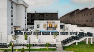 a white house with a balcony with plants at Atlanticblu hotels & Resort in Abuja