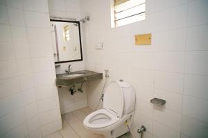 a bathroom with a toilet and a sink at Hotel Raaj Bhaavan - US Consulate - Nungambakkam in Chennai +26 photos