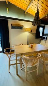 a dining room table with chairs and a lamp at Coeur de bois - 19 in Petit Mesnil