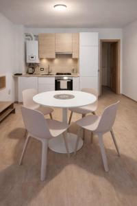 a white table and chairs in a kitchen at Dolomiti Relax Home in Perarolo di Cadore +3 photos