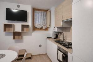 a small kitchen with a table and a counter top at Dolomiti Relax Home in Perarolo di Cadore