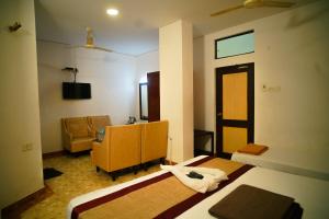 a hotel room with two beds and a chair at Hotel Raaj Bhaavan - US Consulate - Nungambakkam in Chennai