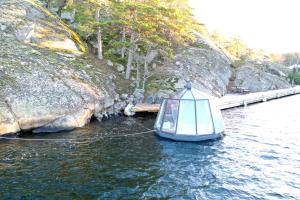 a small boat in a body of water at Stockholm Archipelago Igloo Hut in Tynningö +20 photos