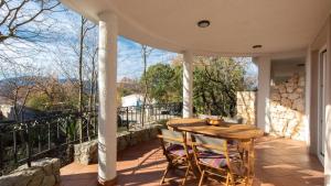 a porch with a wooden table and chairs on a balcony at Appartment house Zara in Brzac