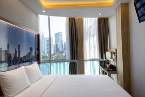 a bedroom with a white bed and a large window at Smart Hotel Thamrin Jakarta in Jakarta +80 photos