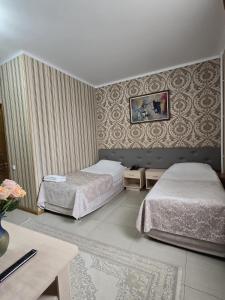 a hotel room with two beds and a table at Gostinitsa Sultan in Aktobe +23 photos
