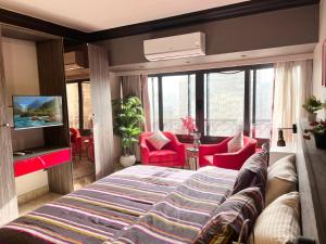 a bedroom with a large bed and red chairs at Deluxe Apartment Partial Nile View in Cairo