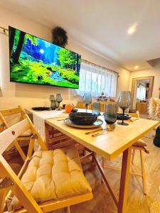 a dining room with a table and a large tv on the wall at UMANI Retreat 2 in Buşteni