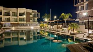 a swimming pool in front of a building at night at Cosmos Residence in Paralimni