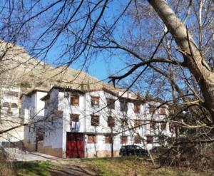 a large white building with a red door at Alborada in Pinos Genil