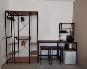 ein Zimmer mit Regalen, einem Tisch und einem Hocker in der Unterkunft BnB Ranco in Ranco