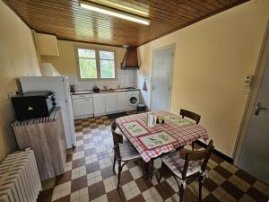 a kitchen with a table and a table and chairs at Gîte la salle in Vivonne