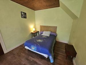 a bedroom with a bed with a blue comforter at Gîte la salle in Vivonne