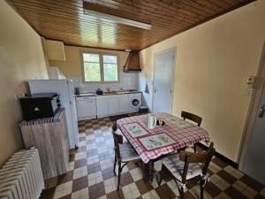 a kitchen with a table and chairs and a kitchen with a refrigerator at Gîte la salle in Vivonne