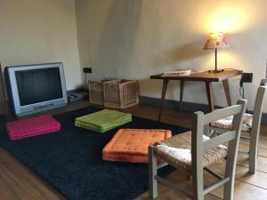 a living room with a tv and a table and chairs at Le refuge de théoline in Lathus St Remy