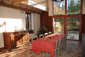 a room with a long table with chairs and a christmas tree at Le refuge de théoline in Lathus St Remy +11 photos