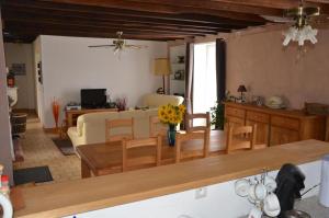 a kitchen and living room with a table and chairs at Les lilas in Lhommaizé