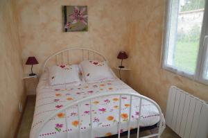 a bedroom with a white bed with flowers on it at Les lilas in Lhommaizé
