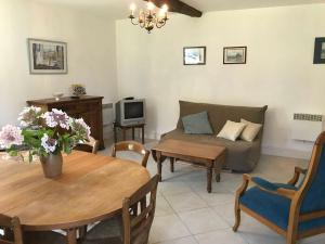 a living room with a couch and a table at Gîte lamarlière in Savigny-sous-Faye +5 photos