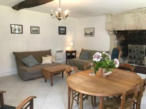 a living room with a couch and a table at Gîte lamarlière in Savigny-sous-Faye