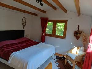 a bedroom with a bed and a window and a chair at Hoenderhof in 't Haantje