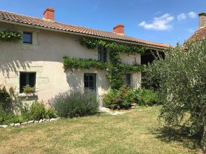 a white house with plants on the side of it at Gîte lamarlière in Savigny-sous-Faye