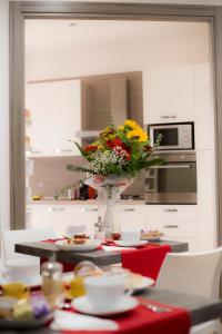 a kitchen with a table with a vase of flowers at B&B Homedesign in Salerno +17 photos