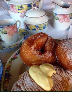 a plate with donuts and cups of tea on a table at Casa Blu Cobalto in Maiori