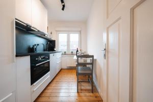 a kitchen with white cabinets and a wooden floor at Gemütliches Nest in Rinkerode in Drensteinfurt